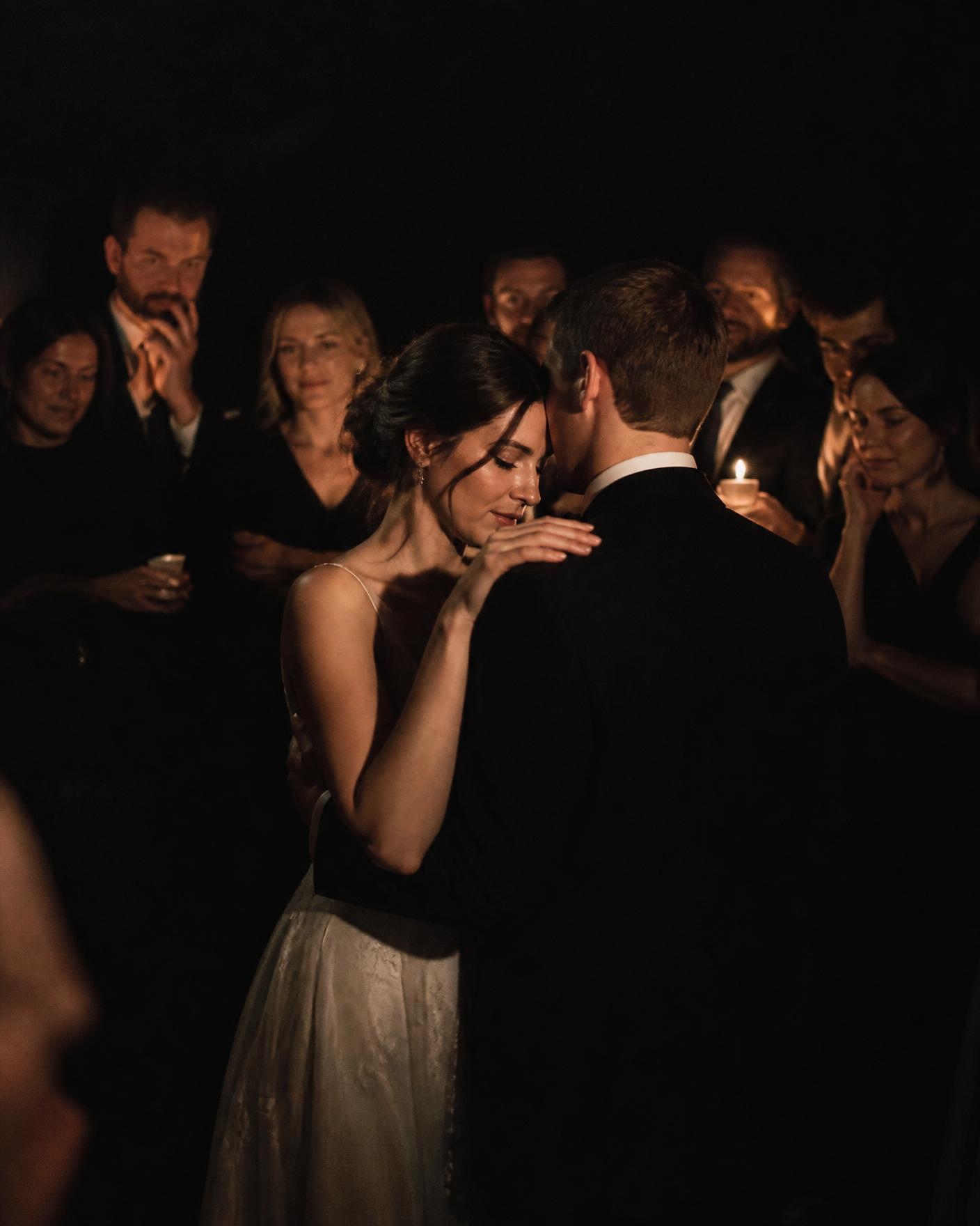 A couple's first dance at a Central Florida wedding, guests circled close in low warm light